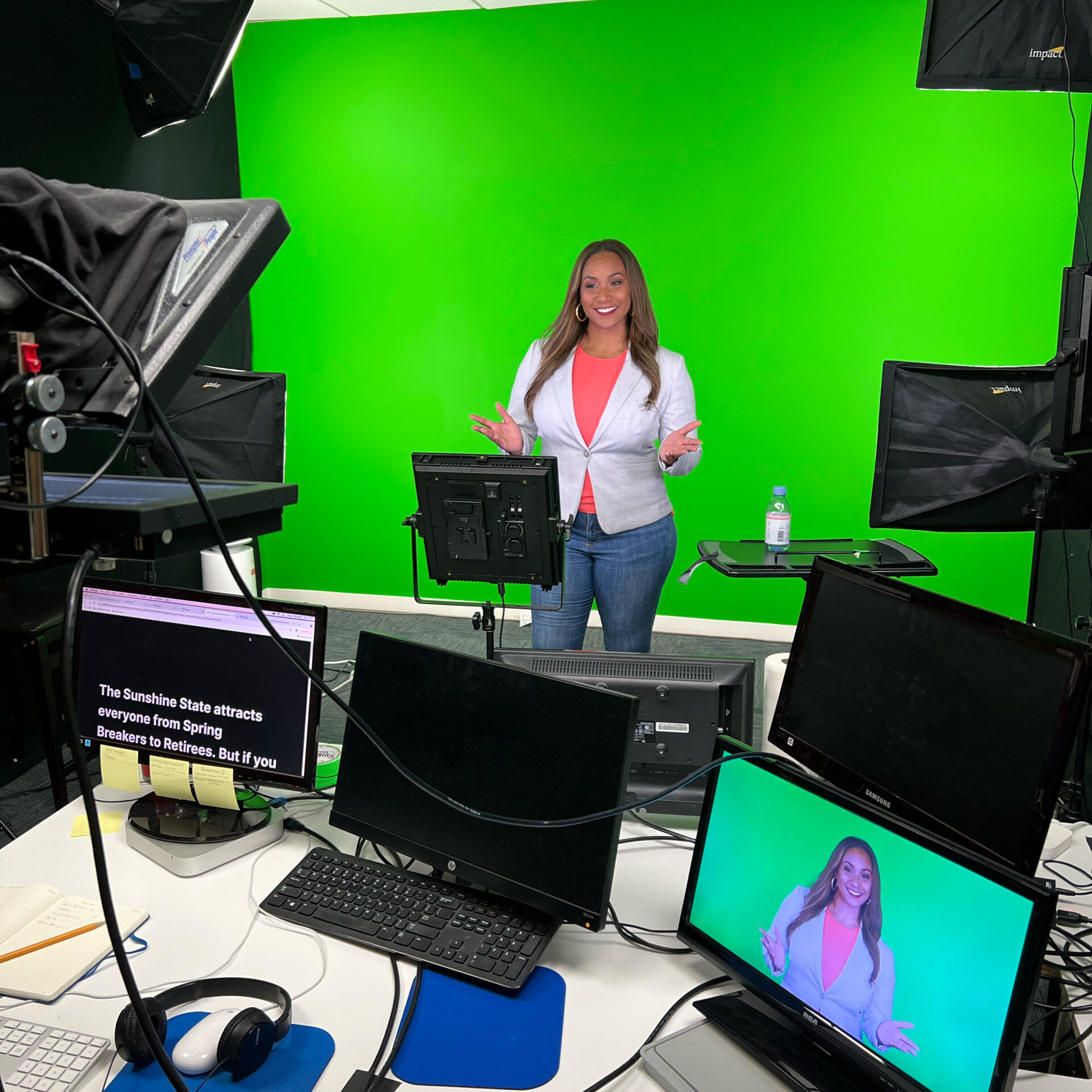 Tamika in front of a green screen in a video production room